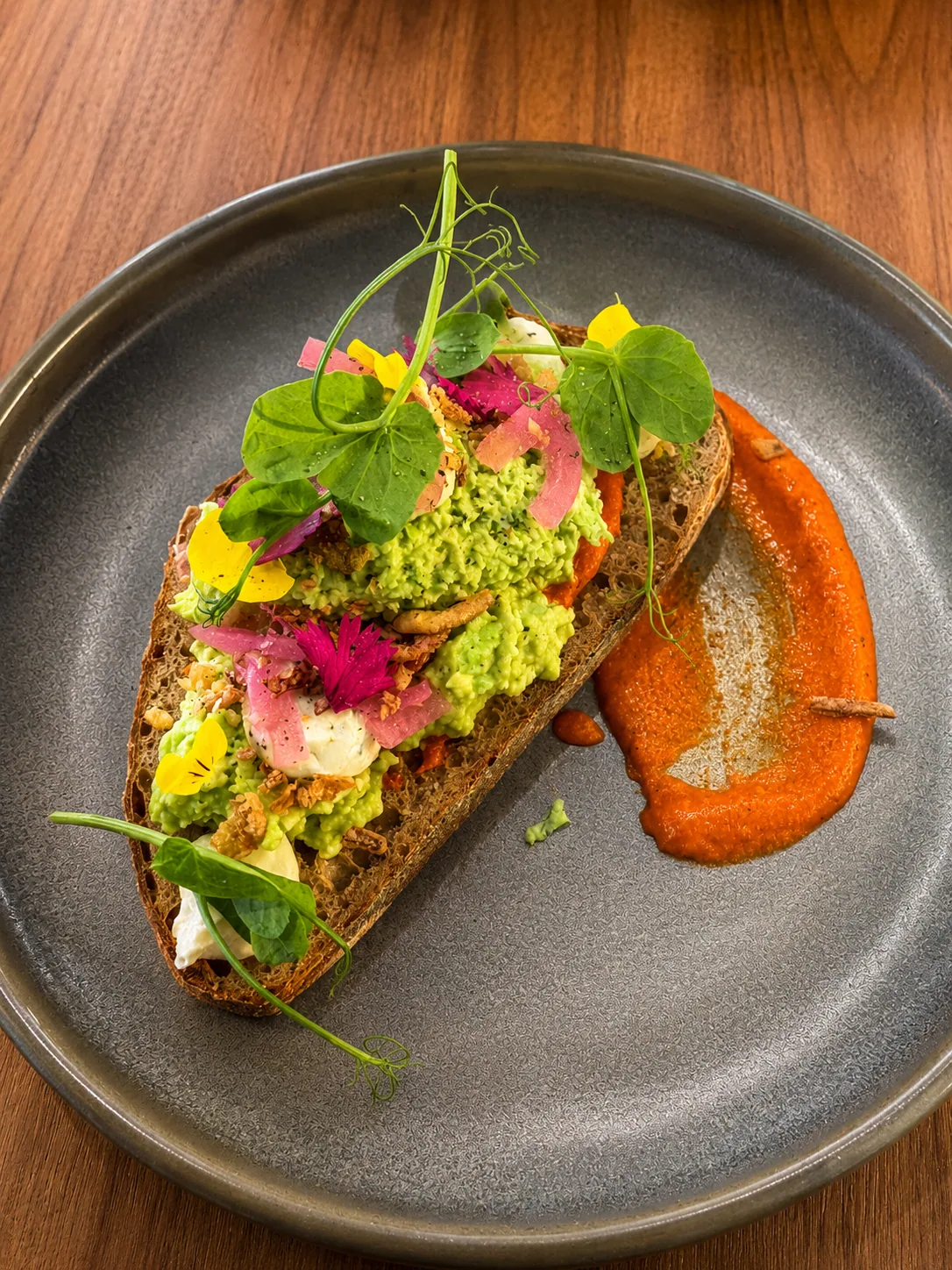 Smashed avocado toast with flowers and tomato relish