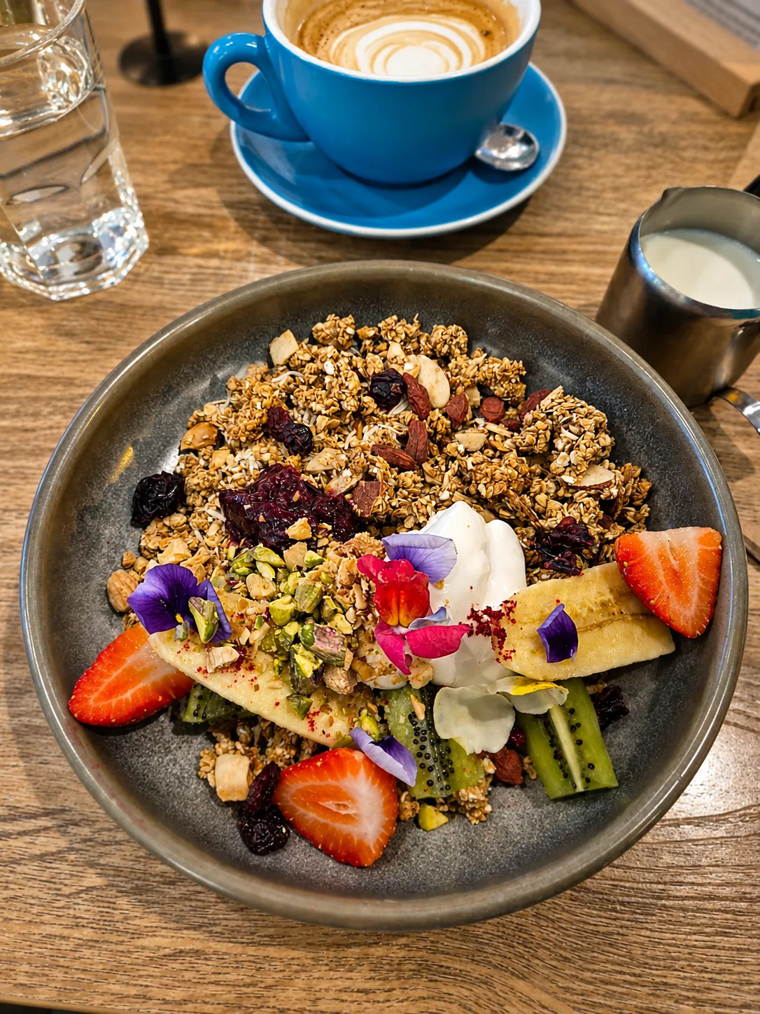 House-made granola with fruit and a blue coffee cup at Cafe Nineteen